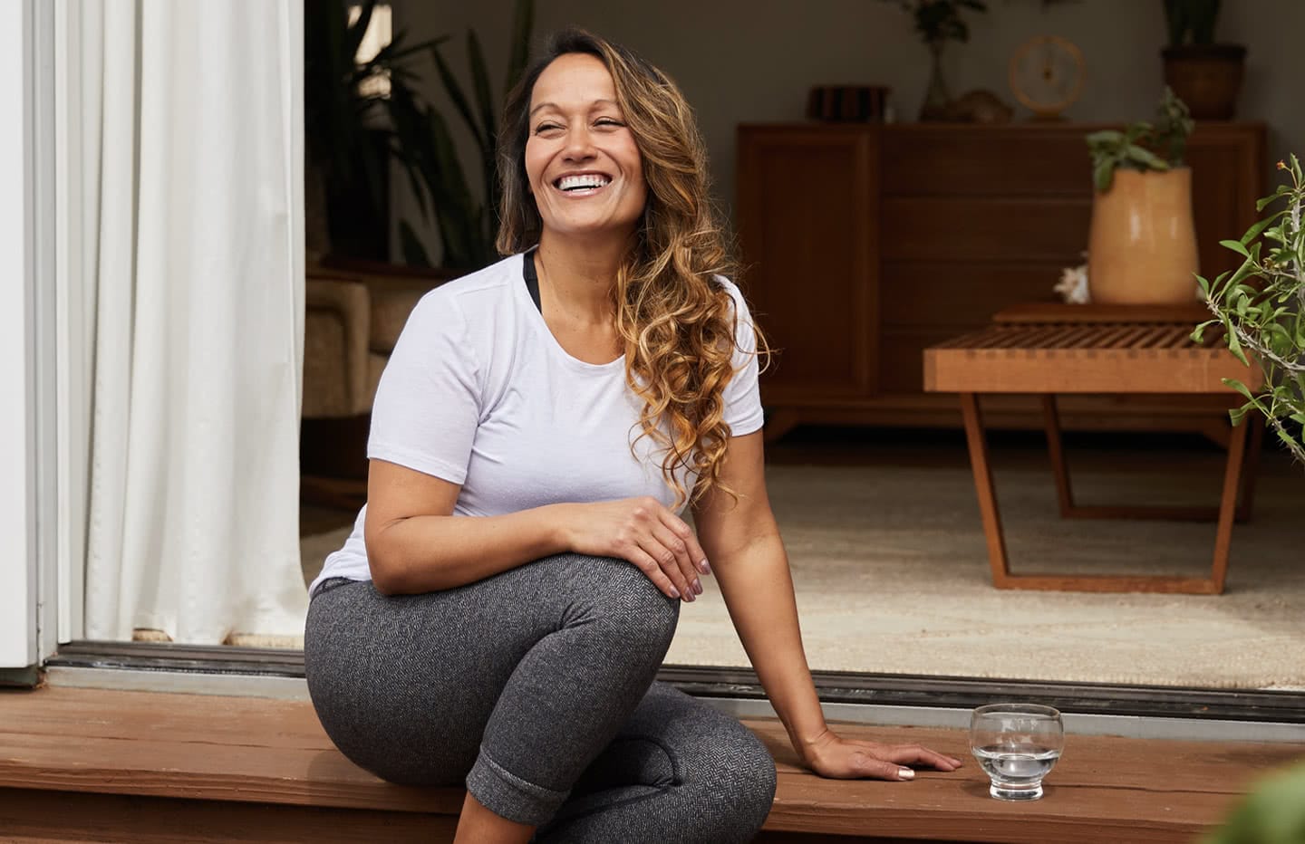female sitting on step smiling and laughing