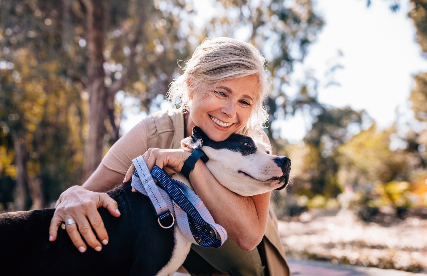 Woman hugging her dog smiling