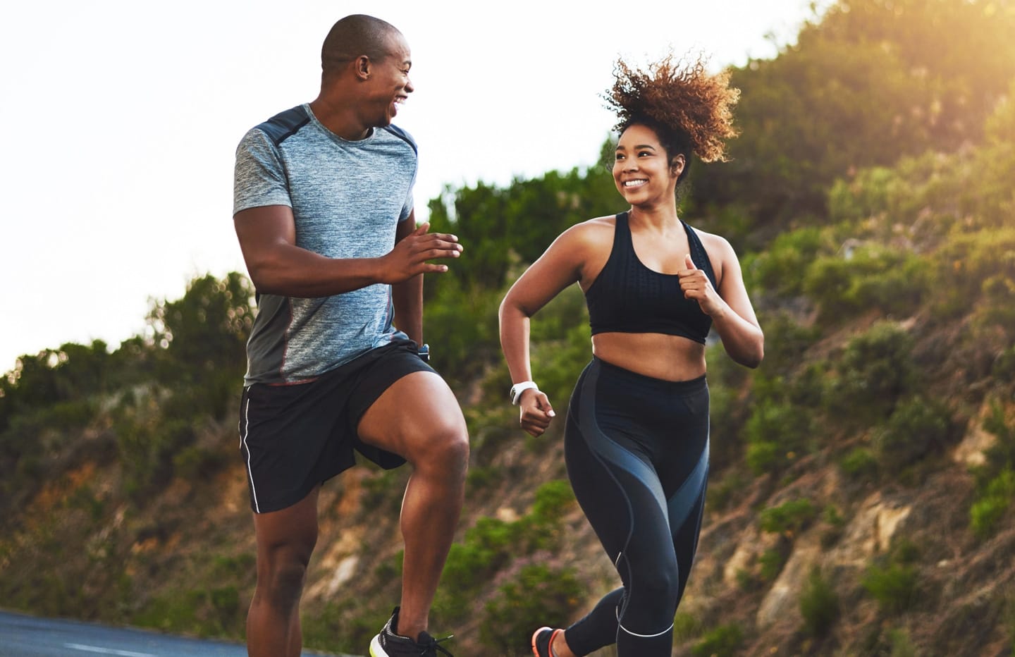 Woman and man looking at eachother while running and smiling