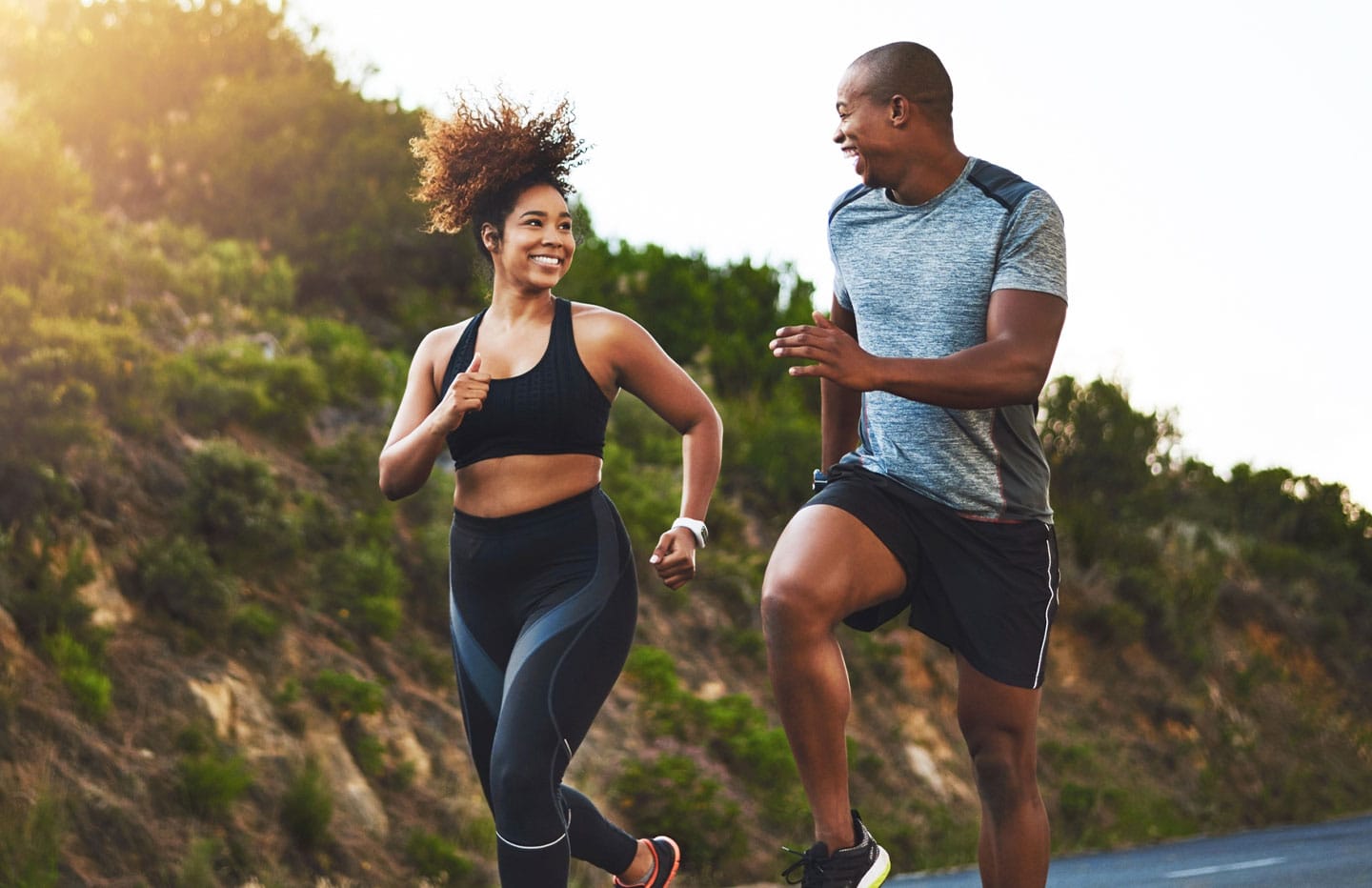 Man and woman looking at eachother smiling while running