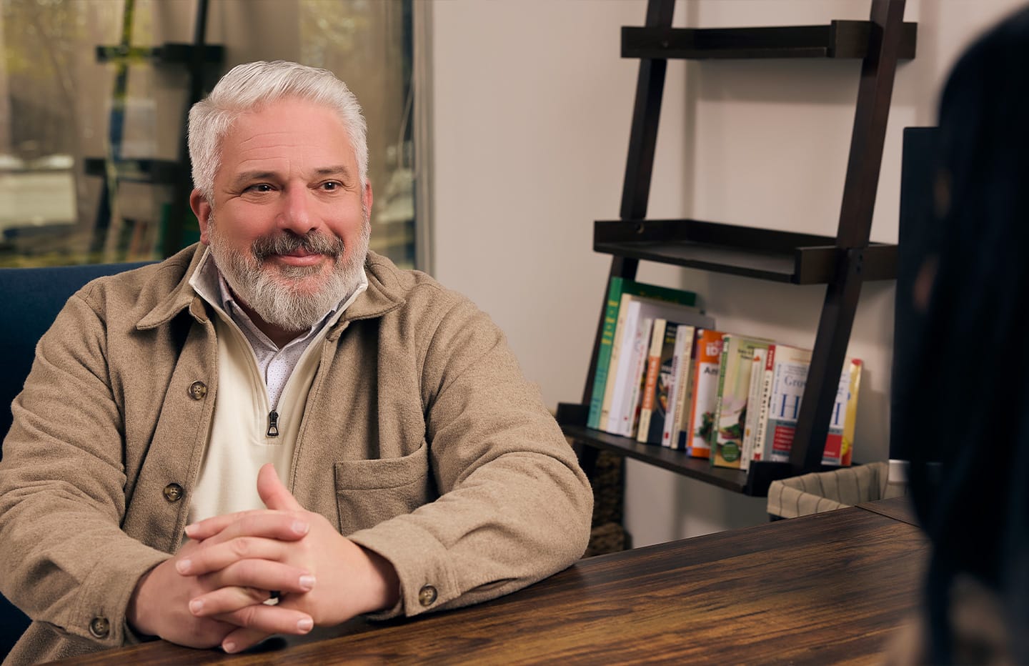 Man across from woman at desk talking