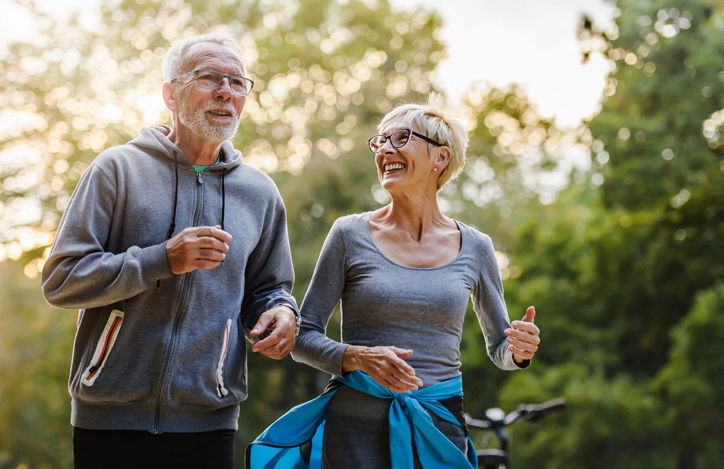 Older man and woman running and smiling